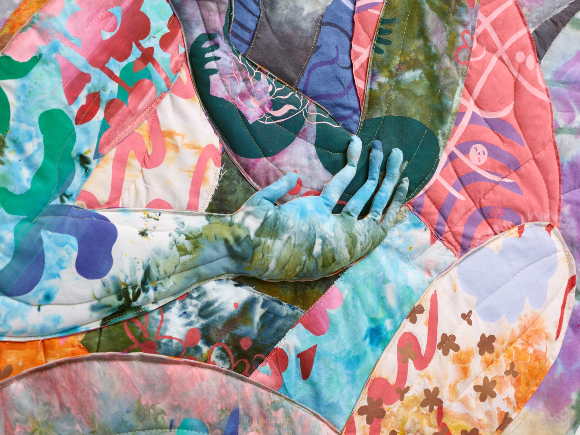 detail of a textile hand on vivid, patterned fabric