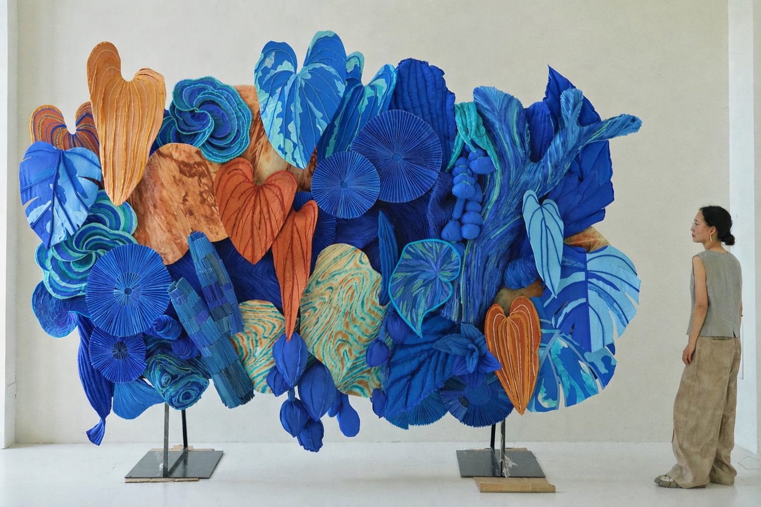 the artist standing near a blue and orange botanical installation